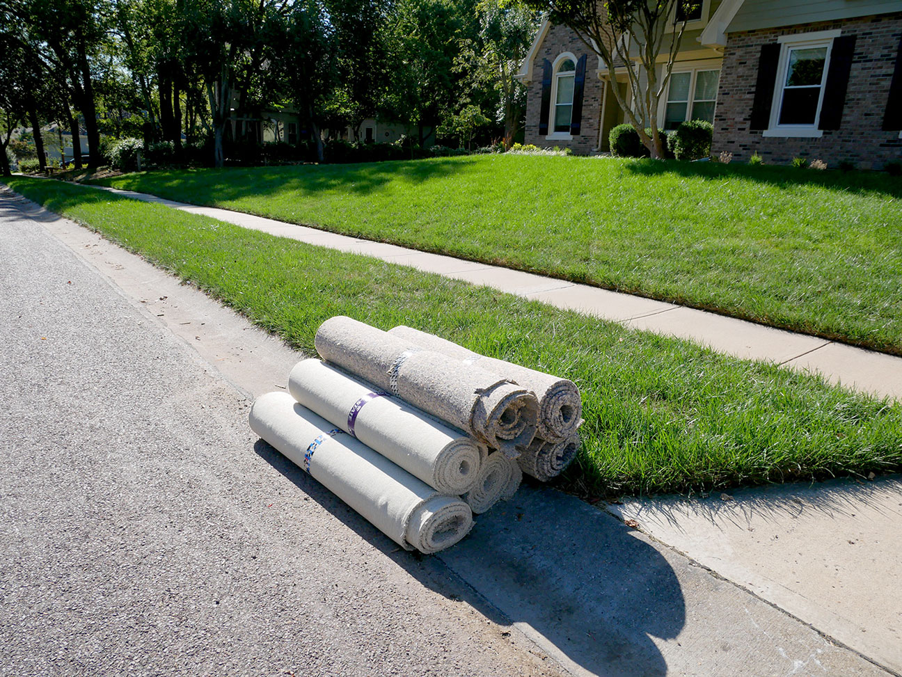 Seven rolls of carpeting placed at the curb of an Overland Park home for bulky item pickup