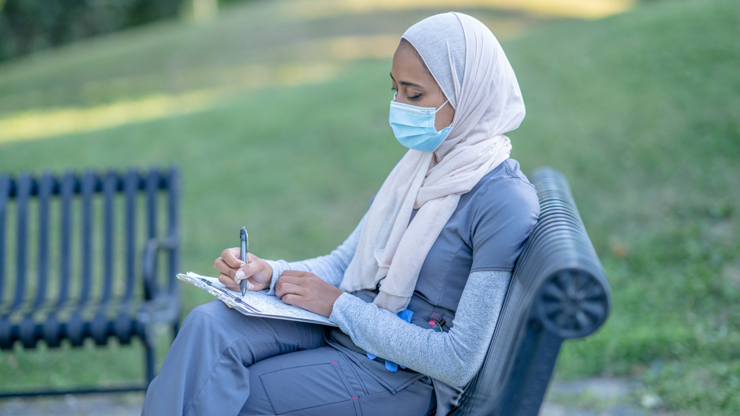 woman bench hijab papers nurse web