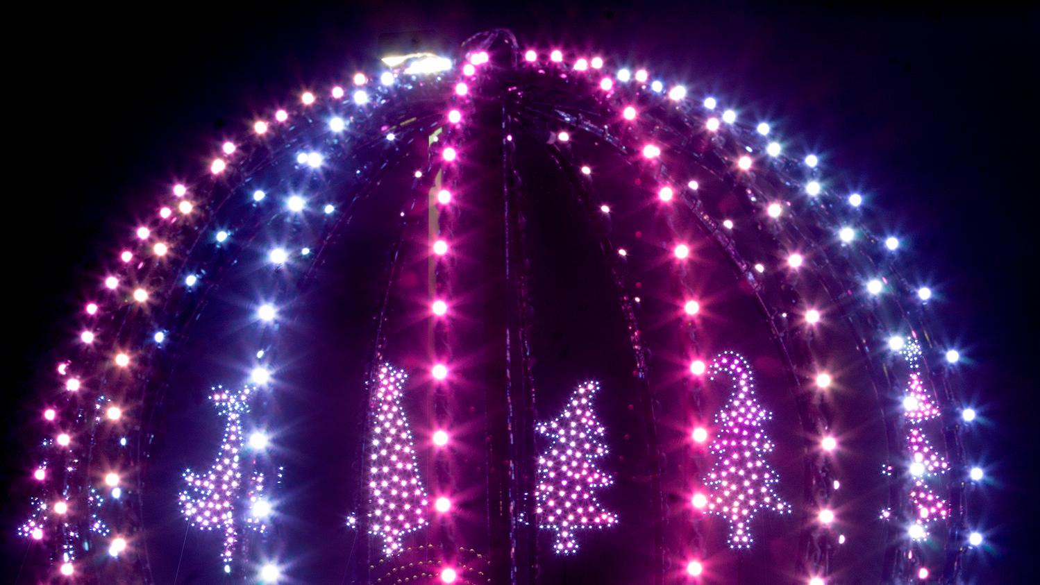 A dome glows purple and blue as part of Holiday Lights on Farmstead Lane.