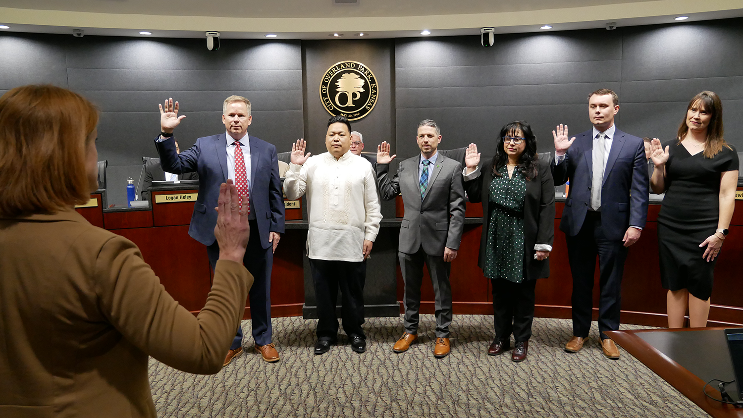 New and returning City Council members raise their right hands as they are sworn into office.