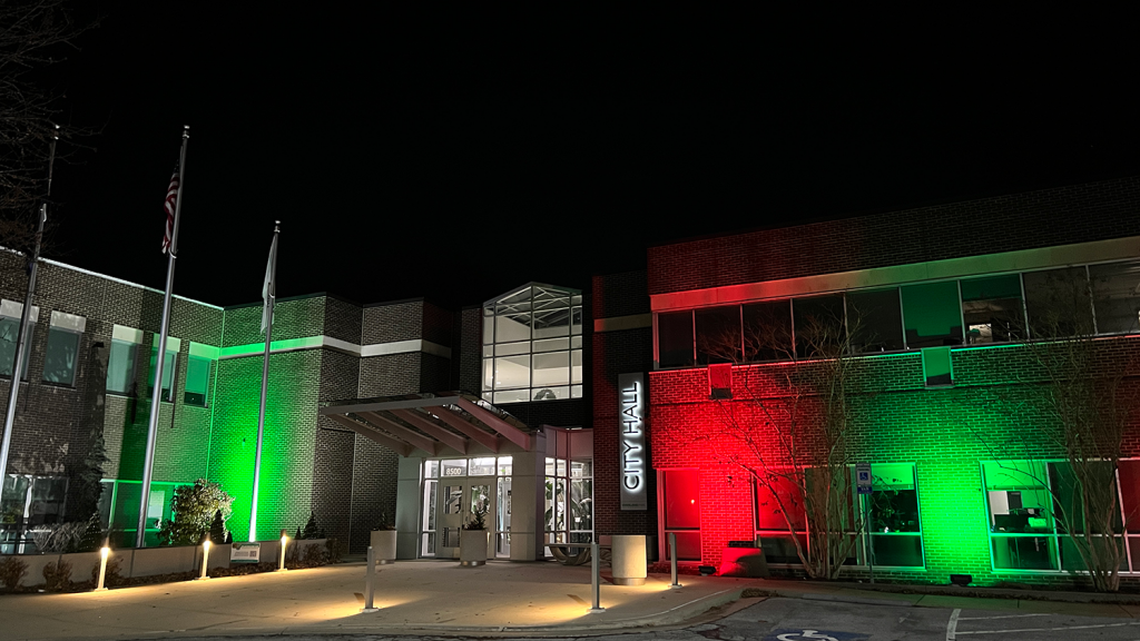 The front exterior of Overland Park City Hall lights up in red and green for the holidays.