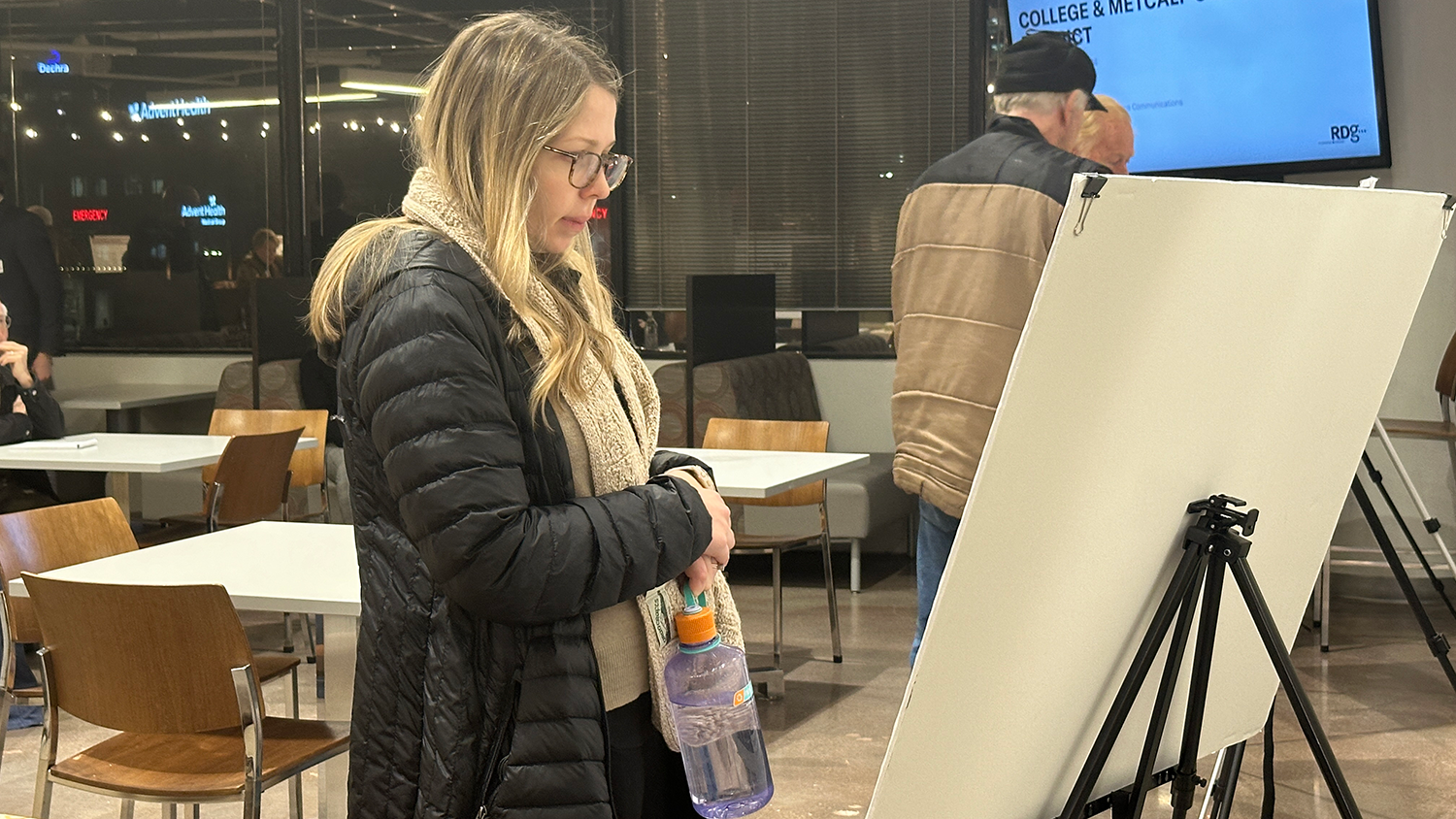 A resident looks at information displayed on a presentation board at a public information meeting.