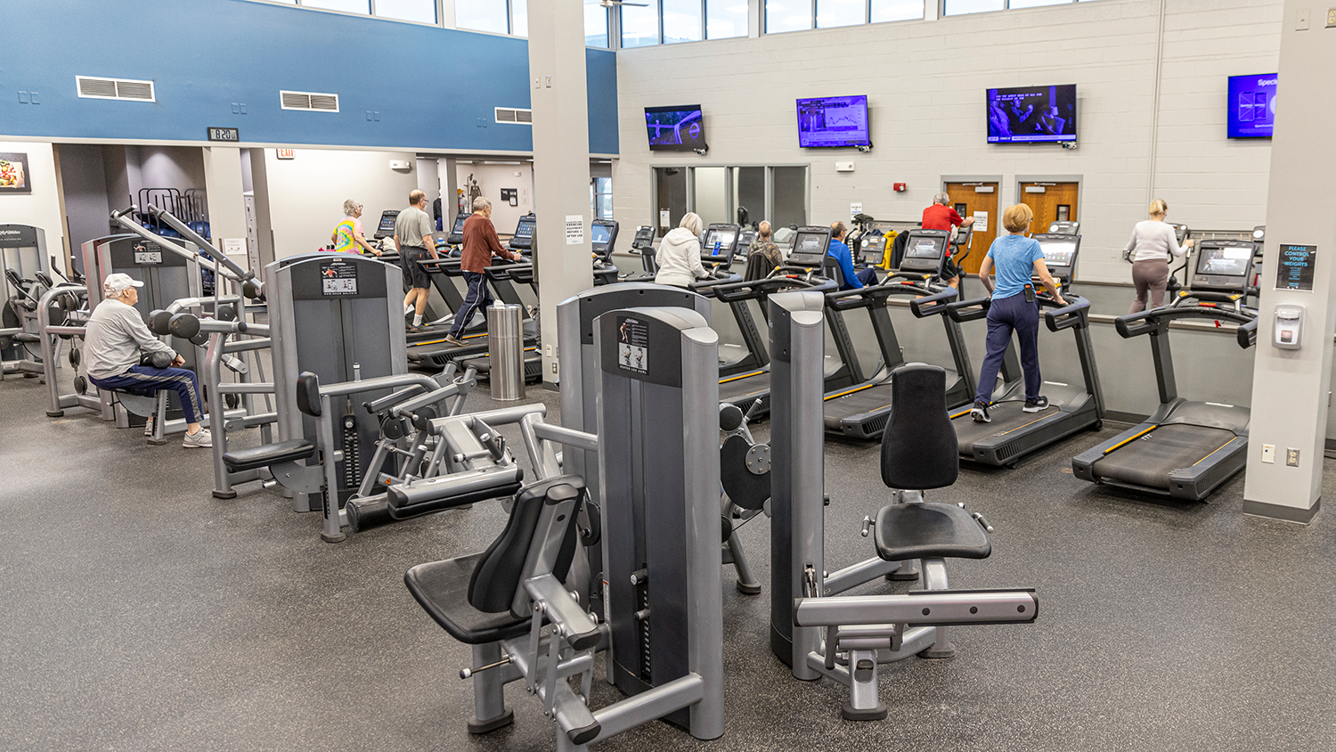 A group of individuals walk on a row of treadmills at Tomahawk Ridge Community Center.