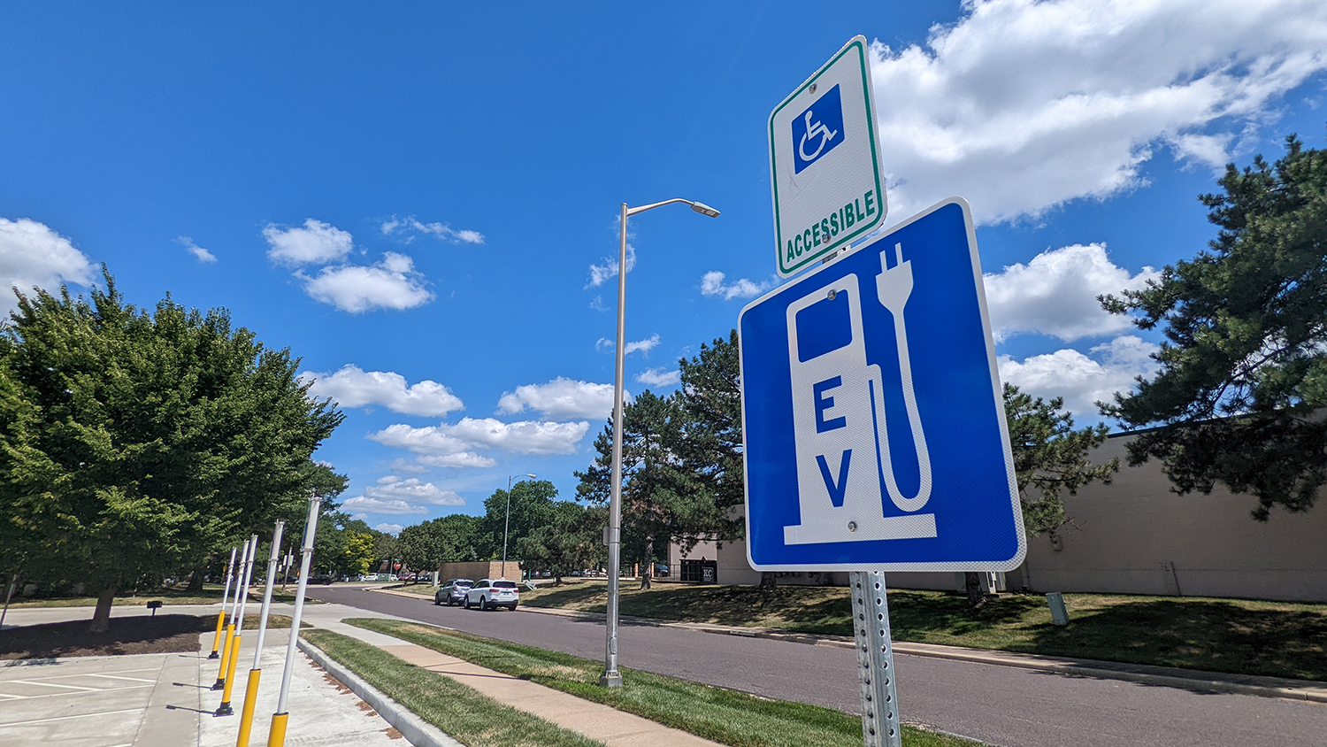 A blue EV charging sign posted in the Myron E. Scafe Building parking lot.