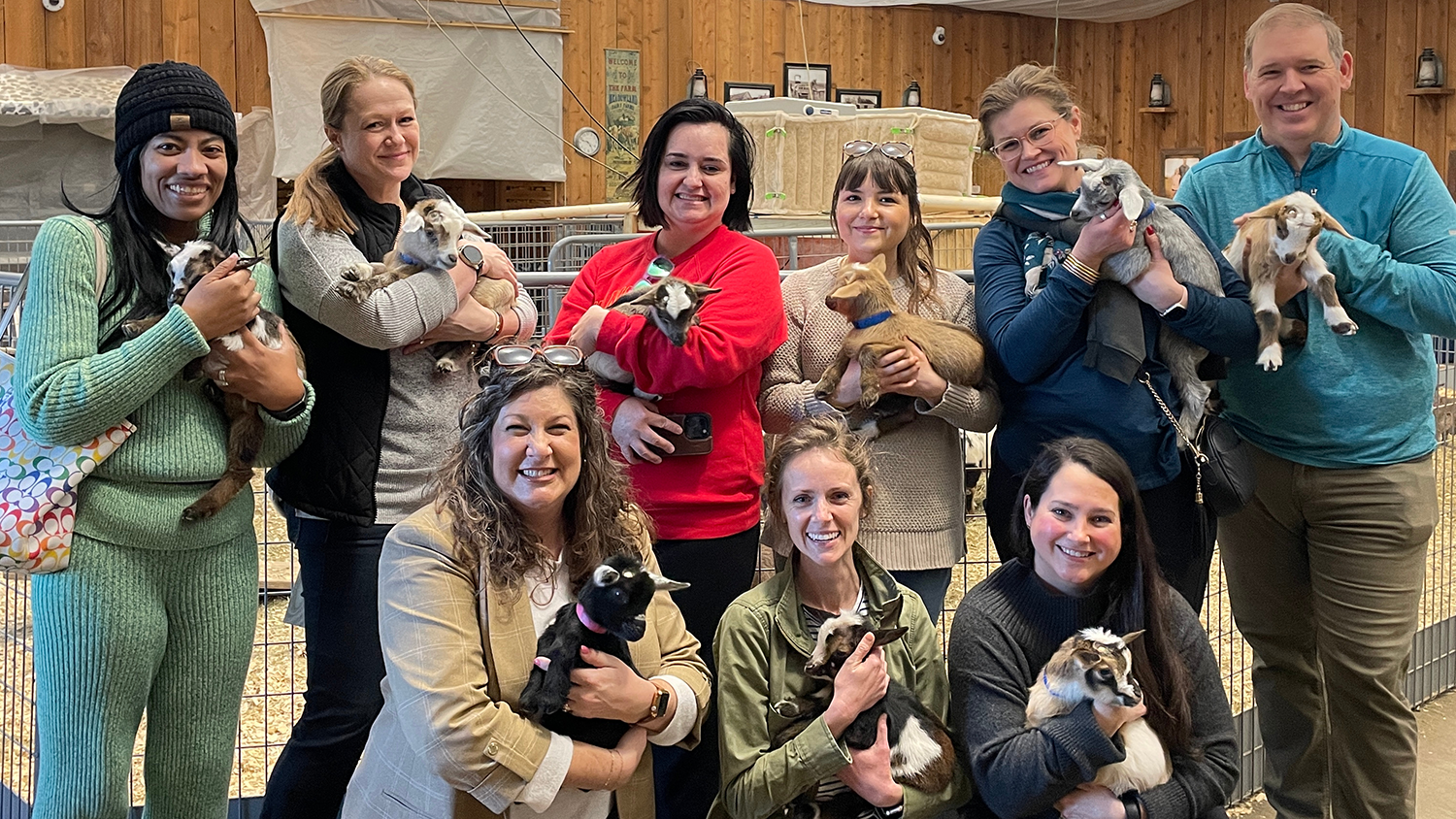 Friends of the Farmstead members pose holding baby goats at Deanna Rose Children's Farmstead.
