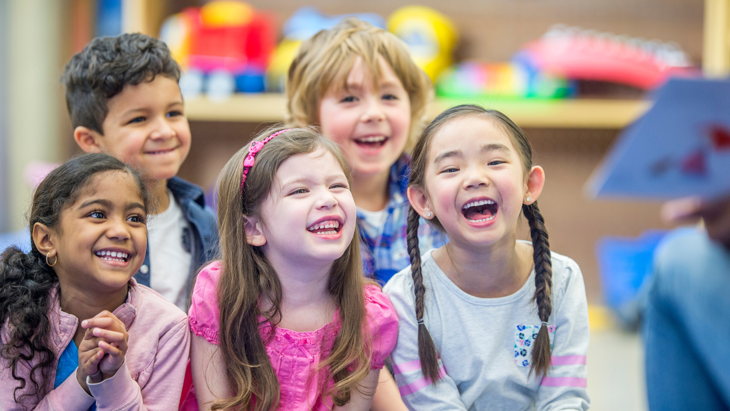 A group of sitting children laugh together.