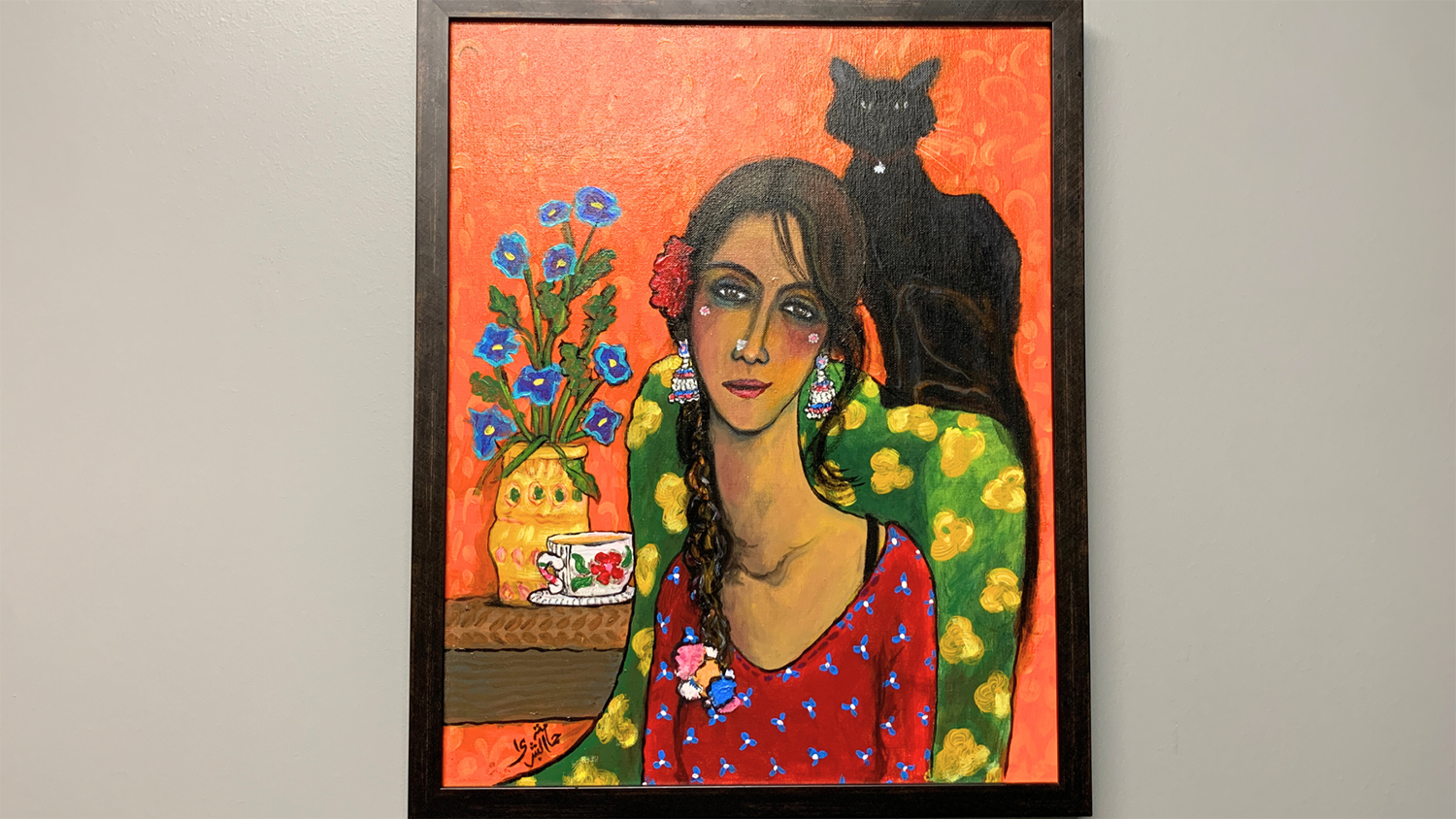 A painting by Hamama Bushra hangs on a wall as part of an exhibit at Art at the Center.