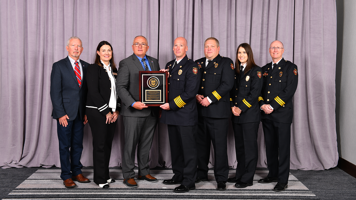 Overland Park Police Department Officers and City leaders pose with accreditation plaque.