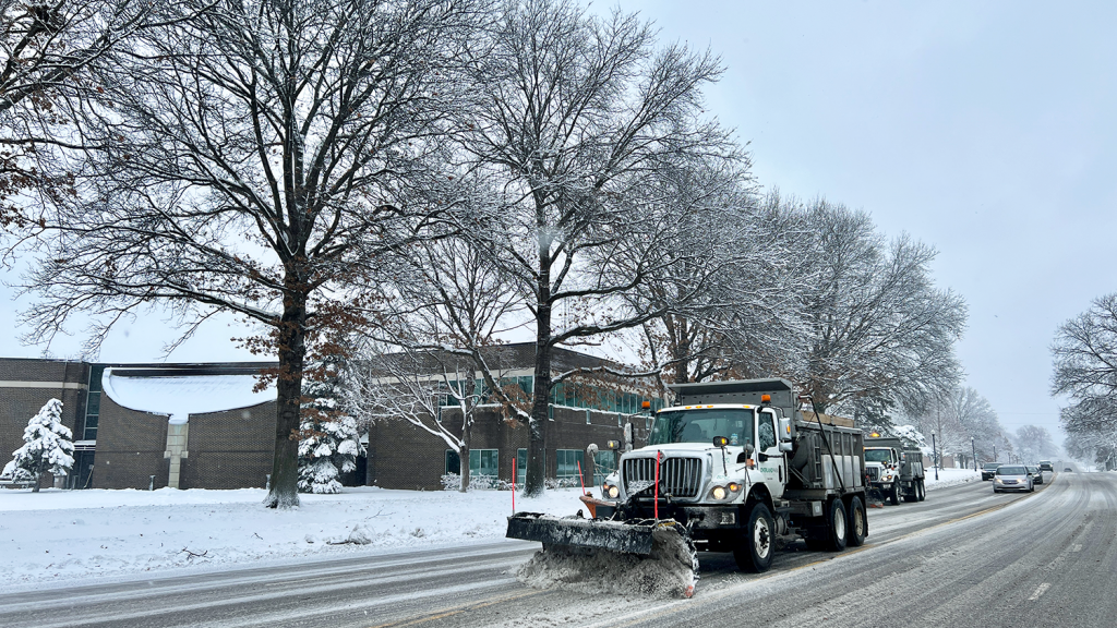 A City snow plow clears the road in front of City Hall.
