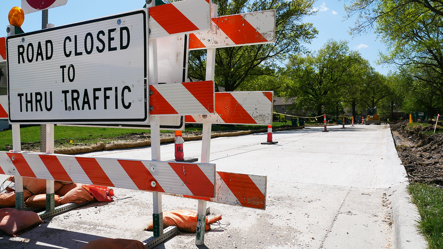 Large road signs that read "Road Closed to Thru Traffic" blocks off a road.