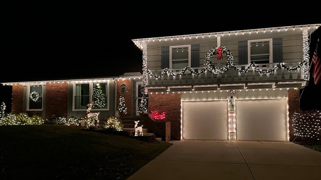 A home decorated in bright holiday lights and decorations at night.