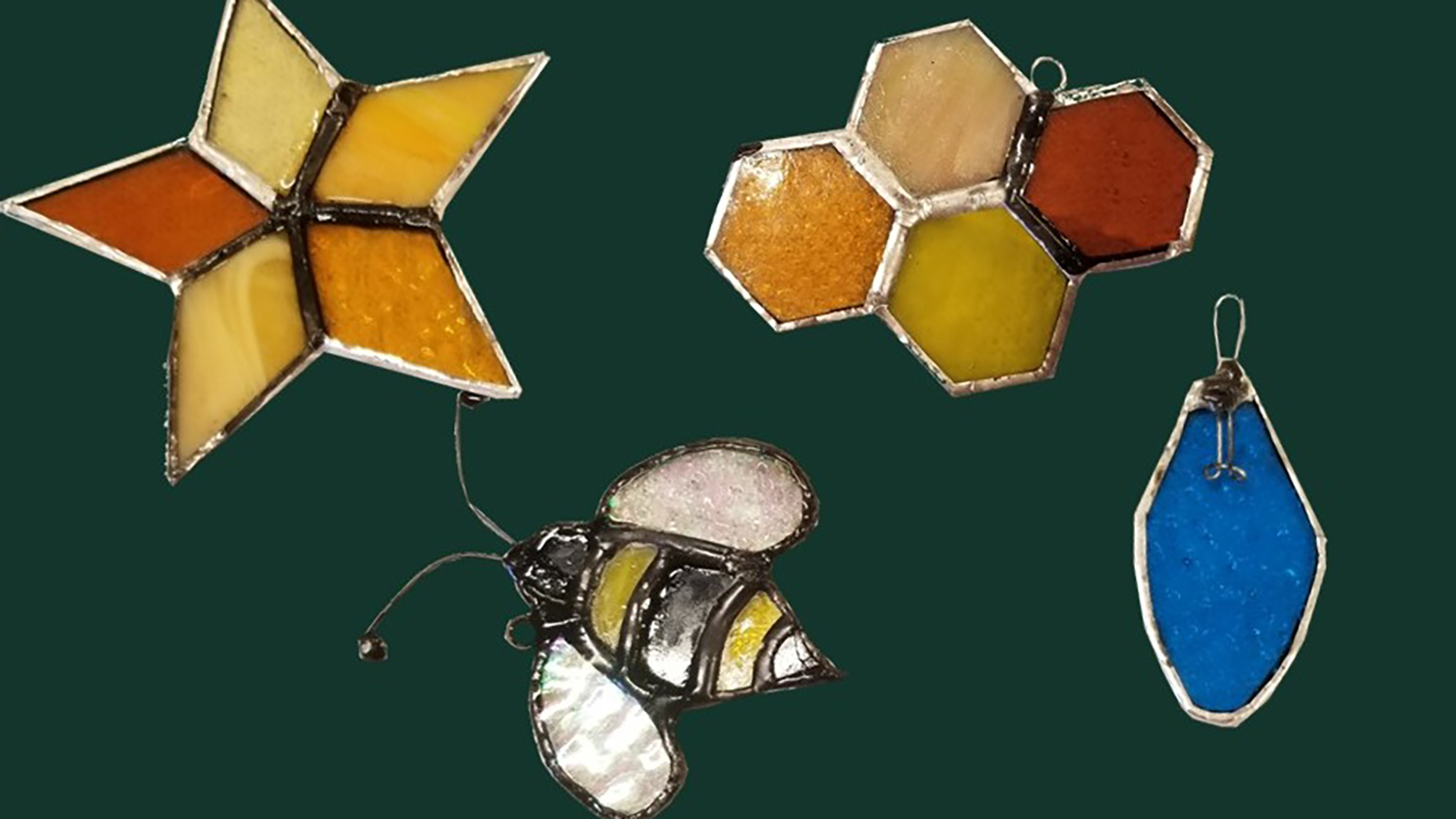 Various pieces of stained glass, featuring a star, a bee and a blue holiday light bulb.