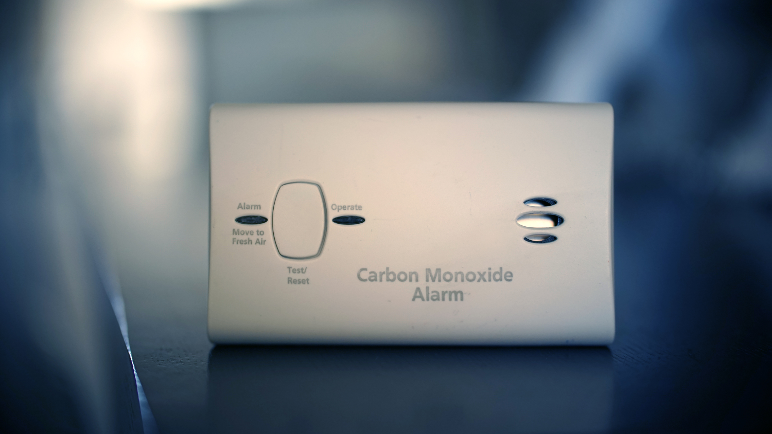 Close-up of a carbon monoxide alarm sitting on a shelf.